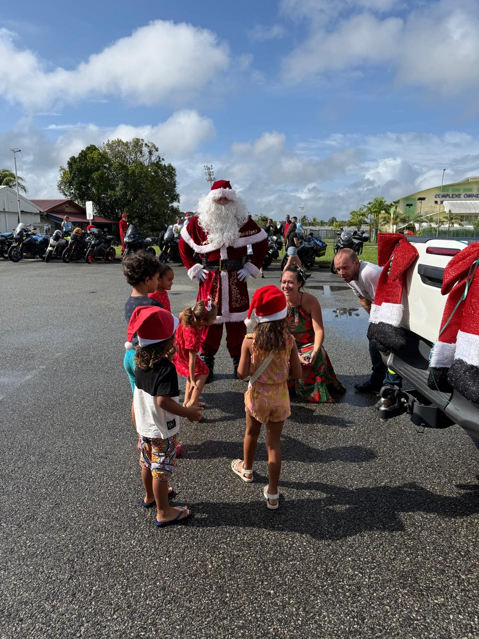 Père Noël motard remettant des cadeaux aux enfants — KdoRide 2025