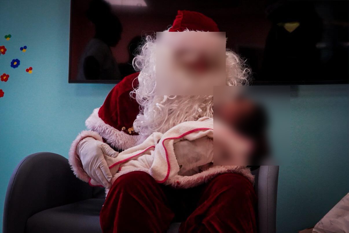 Père Noël prenant un nourrisson dans ses bras à l'hôpital — KdoRide